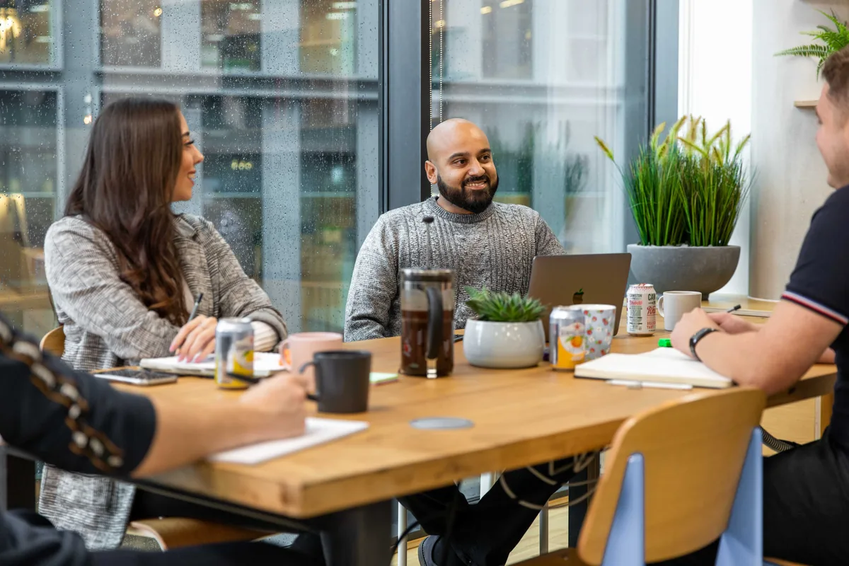 An employer team meeting round a table in an office